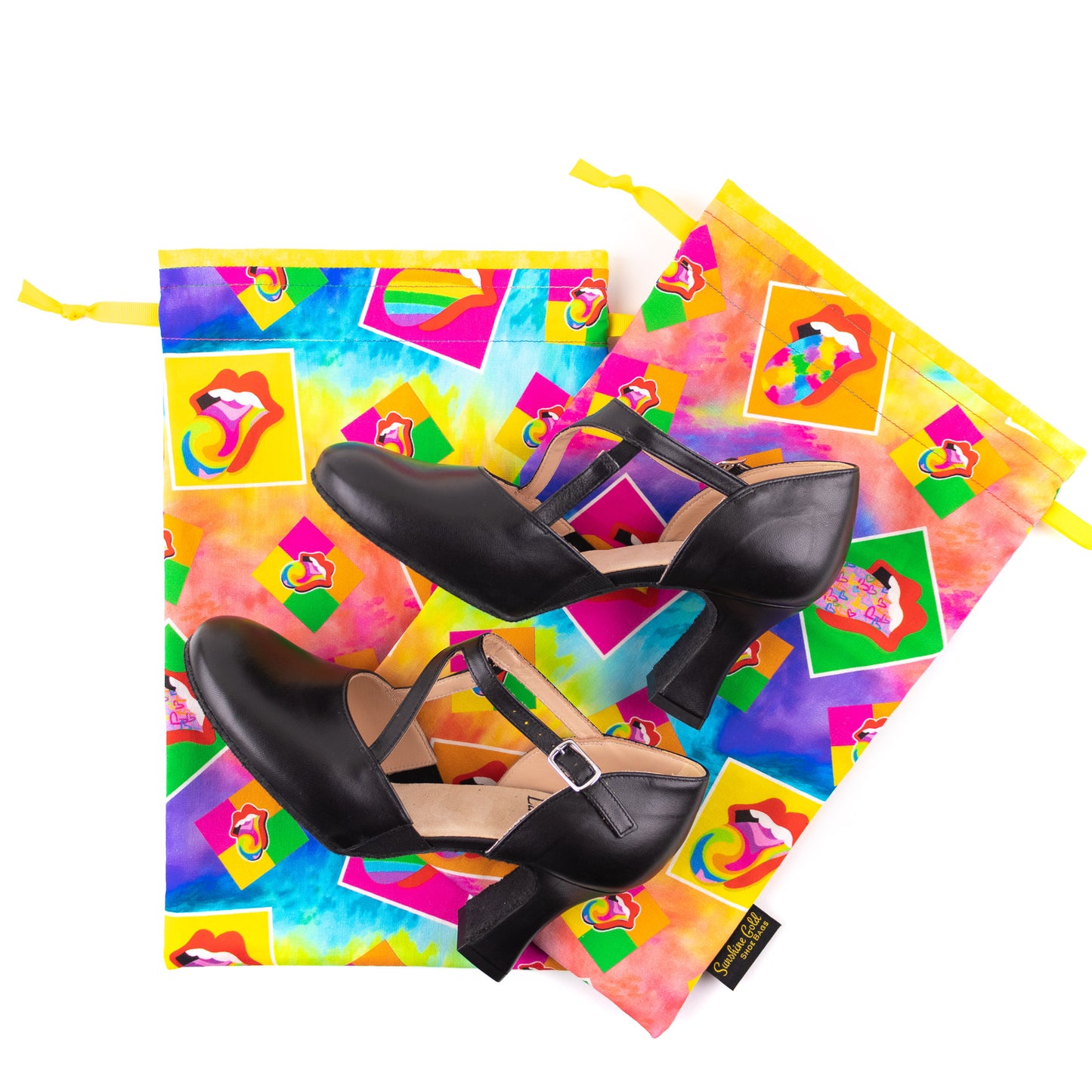A pair of black high-heeled character dance shoes with two colorful dance shoe bags