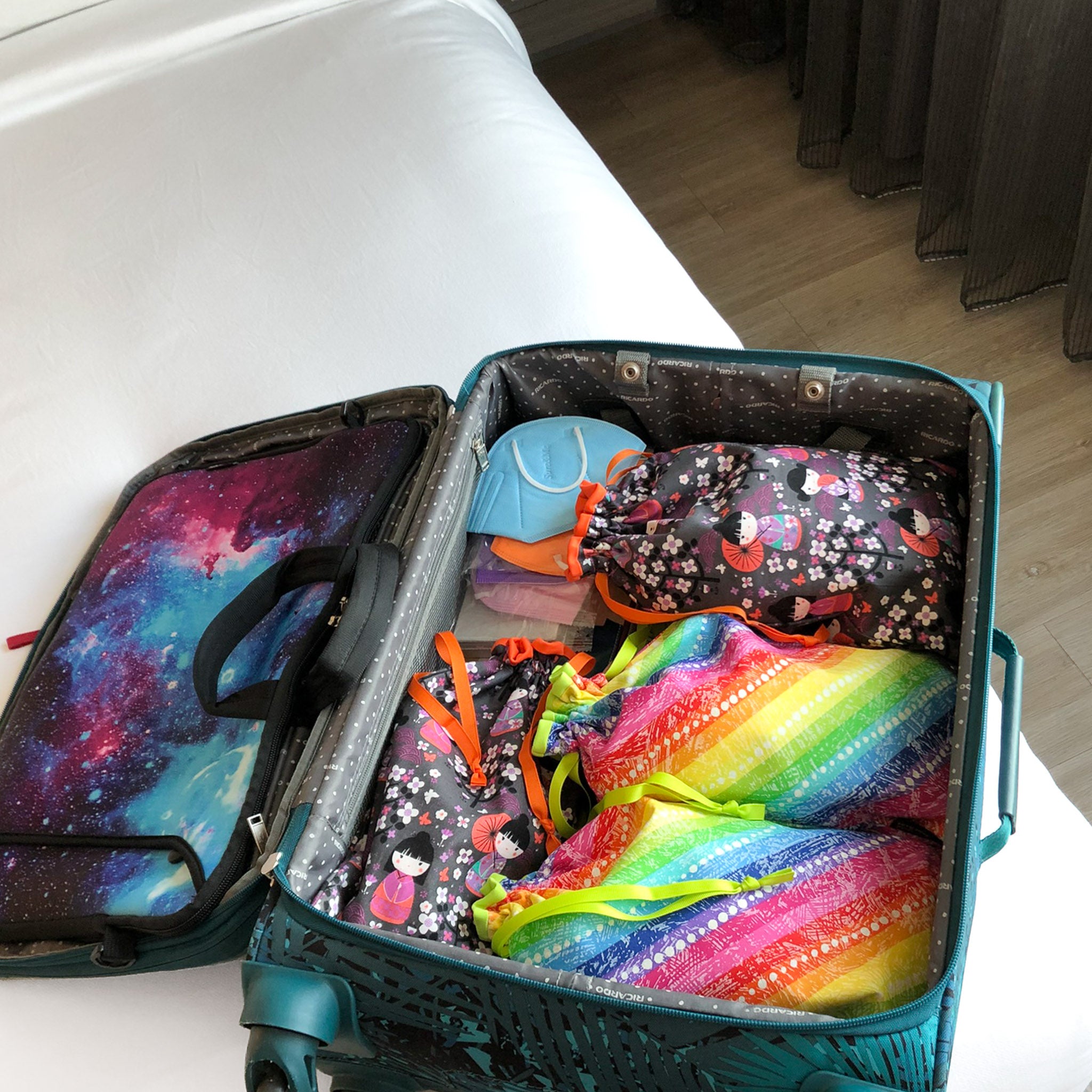 An open suitcase with colorful shoe bags inside