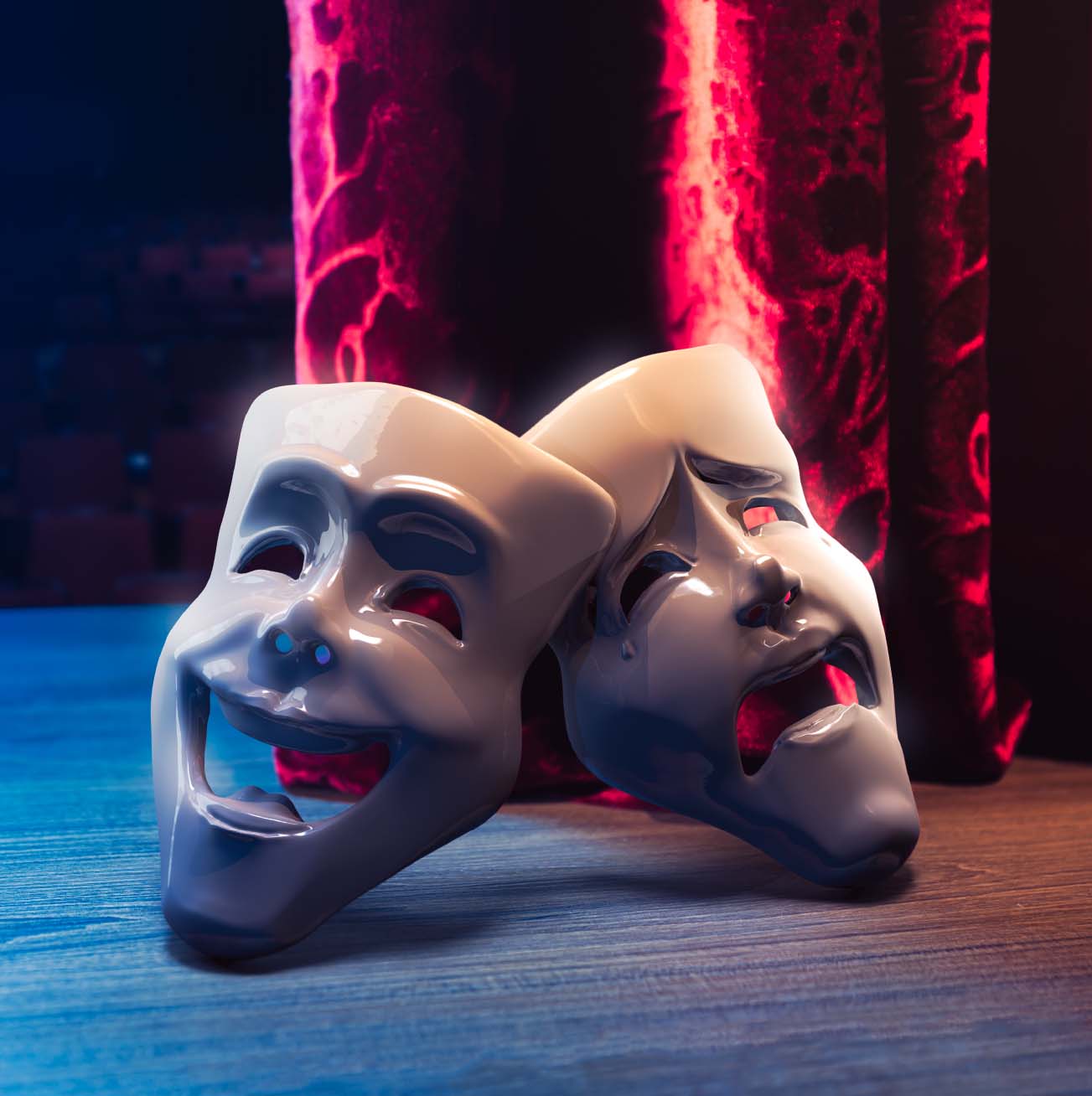 A pair of theatre masks, one laughing and one crying, on a stage with a red curtain behind them